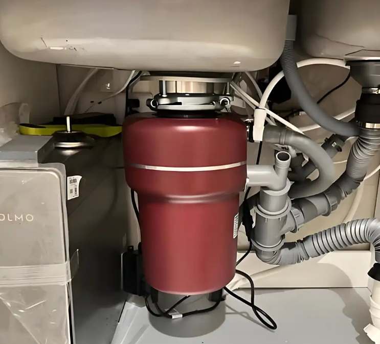 What is the working principle of a kitchen waste disposer?